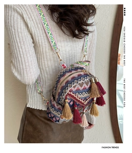 Detail of colorful ethnic woven backpack featuring long tassels and geometric embroidery