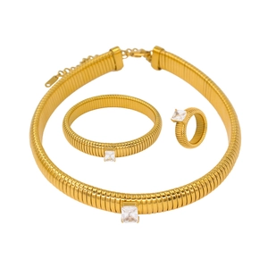 Detailed view of gold jewelry set with striped texture and square zircon gemstones
