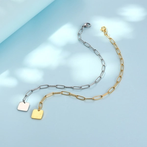 Minimalist gold and silver paperclip chain bracelets with square tags on blue background