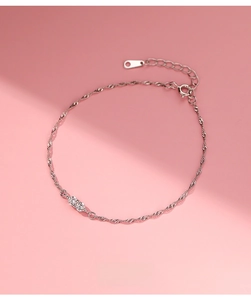 Macro detail of S925 sterling silver water wave chain featuring two round cubic zirconia