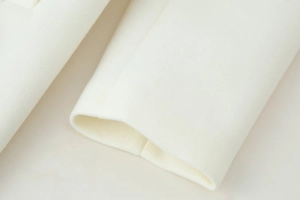 Detail of white wool jacket sleeve cuff showing high-quality fabric texture and fine stitching