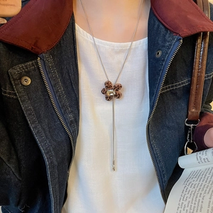 Detail of leopard print flower pendant with crystal on silver snake chain necklace