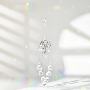 Detail of silver Tree of Life crystal suncatcher casting rainbow light on a white wall