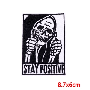 Detail of Stay Positive skull embroidery patch with thumbs up for denim jacket DIY