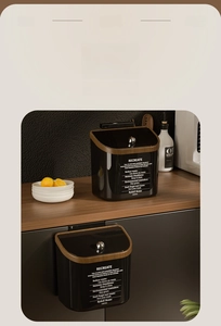 Dual-use kitchen trash bin in black mirror finish with wood grain rim and silver handle