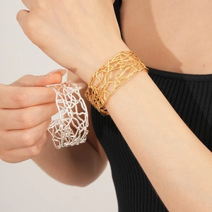 Gros plan de bracelets joncs évidés en or et argent avec un éclat métallique pur