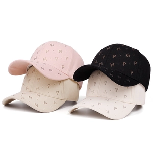 Detail of baseball caps in four colors featuring rhinestone PN letter decorations