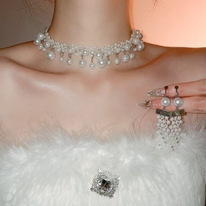 Detail of French vintage pearl and rhinestone necklace with matching tassel earrings on model
