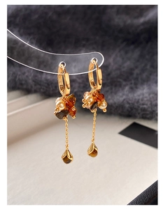 Detailed view of vintage gold drop earrings with tiger eye beads and pearl fringe accents