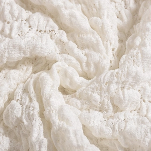 Detailed close-up of premium white 3D textured lace fabric with elegant hollow embroidery