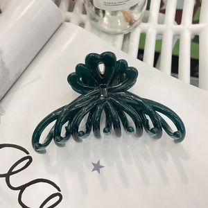 Macro detail of large dark green flower hair claw clip in high gloss resin finish