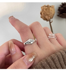 Macro detail of S925 sterling silver bamboo joint ring and engraved seal ring set on finger