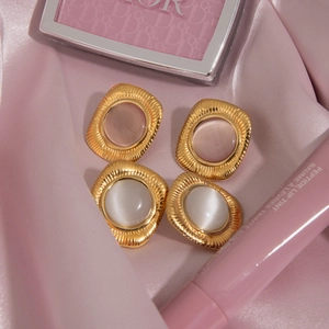 Golden square ribbed earrings set with pink and white cat eye stones on silk