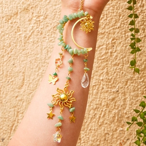 Detail of suncatcher with green aventurine crystals, golden moon and sun pendants