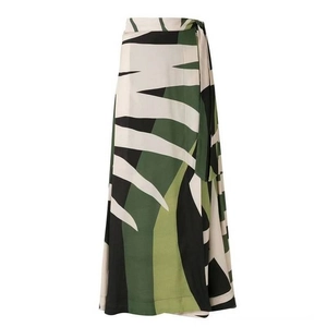 Detail view of wrap skirt featuring textured fabric and tropical green leaf print design