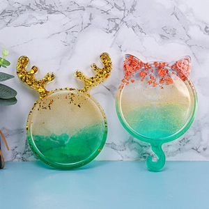 Detalle de posavasos de resina con forma de gato y alce con purpurina y ganchos
