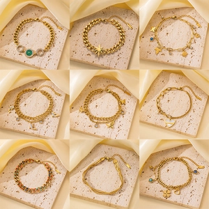 Colección de pulseras doradas con dijes de mariposa y ojo turco sobre bases de piedra