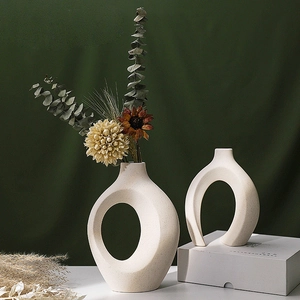 Modern Nordic beige ceramic vases with cutout design and dried flowers for home decor