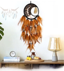 Detail of moon-shaped dream catcher with natural agate slice and brown feathers hanging
