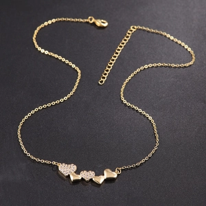 Exquisite gold interlocking heart necklace with zircon pavé on a black textured surface
