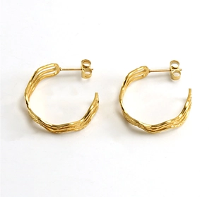 Detail view of gold titanium steel C-shaped earrings with irregular multilayer ripples