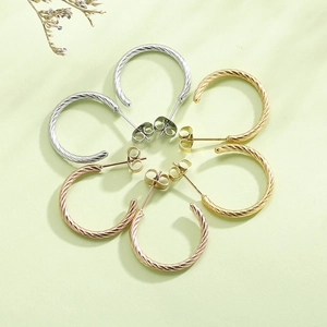 Macro shot of twisted rope texture stud earrings in gold, silver, and rose gold tones