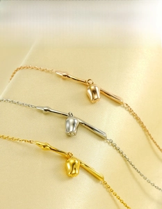 Detailed shot of 18K gold plated stainless steel bracelets with small bell charms