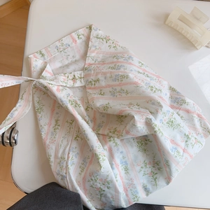 Close-up of a floral cotton bag with a pink striped pattern and a bow drawstring closure