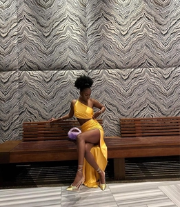 Detail of yellow one-shoulder crop top and high slit satin maxi dress for party wear