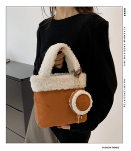 Brown faux suede handbag featuring plush white fleece trim and a round coin purse charm