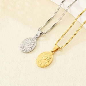 Close-up of gold and silver oval medallion pendants with religious relief on textured fabric