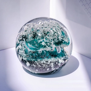 Detailed view of ocean wave crystal ball with green swirling textures and fine bubbles