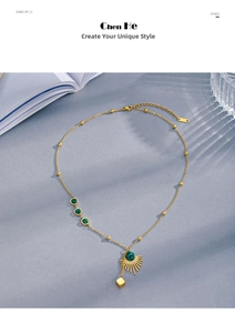 Detail of gold fan necklace with malachite beads and cubic pendant on textured background