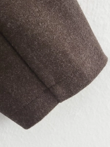 Close-up of deep brown wool texture jacket with premium double-stitch seam details