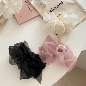 Chiffon tulle butterfly hair claws in beige black and pink on a white decorative setting