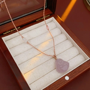 Pink chalcedony Buddha pendant with woven cord in a luxury velvet jewelry box