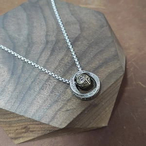 Mobius ring necklace with silver chain and gold rotating bead on hexagonal wood base