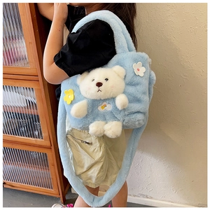 Close-up of sky blue faux fur handbag featuring a cute 3D bear and floral patches