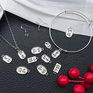 Antique silver blessing jewelry set with engraved charms on black leather backdrop