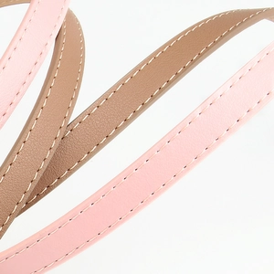 Women's thin faux leather belt in pink and beige colors with white stitching details