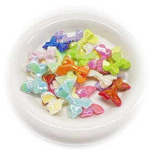 Colorful UV coated bow-shaped beads for DIY jewelry and crafts in a white tray