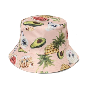 Detail of pink bucket hat featuring cute cartoon cats with pineapple and avocado prints
