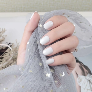 Short square off-white glossy press-on nails with minimalist silver ring on soft mesh fabric