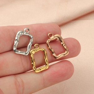 Irregular hollow square pendants in silver, gold, and rose gold on pink silk