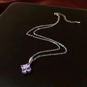 Elegant silver necklace featuring a purple zircon flower pendant on a dark leather background