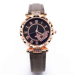 Detail of rose gold watch face featuring Roman numerals and a sparkling heart crystal insert