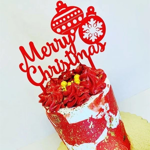 Detail view of a red Merry Christmas acrylic topper on a festive decorated cake