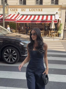 Dettaglio di un set chic con top a fascia e pantaloni in denim nero in una via di Parigi
