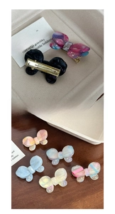 Detail showing the metal duckbill clip mechanism and butterfly hair clip assortment
