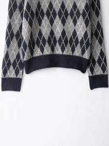 Detailed view of argyle knit pattern and ribbed hem on classic casual sweater